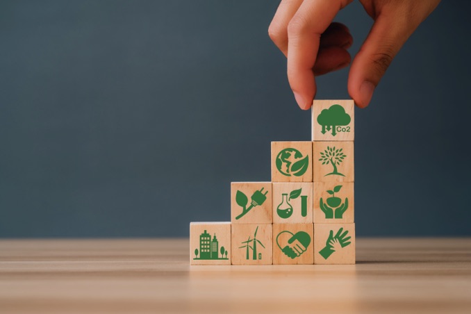 Hand puts the wooden cubes with CO2 emission reduction icon. CO2 emission concept. Green industries business concept.