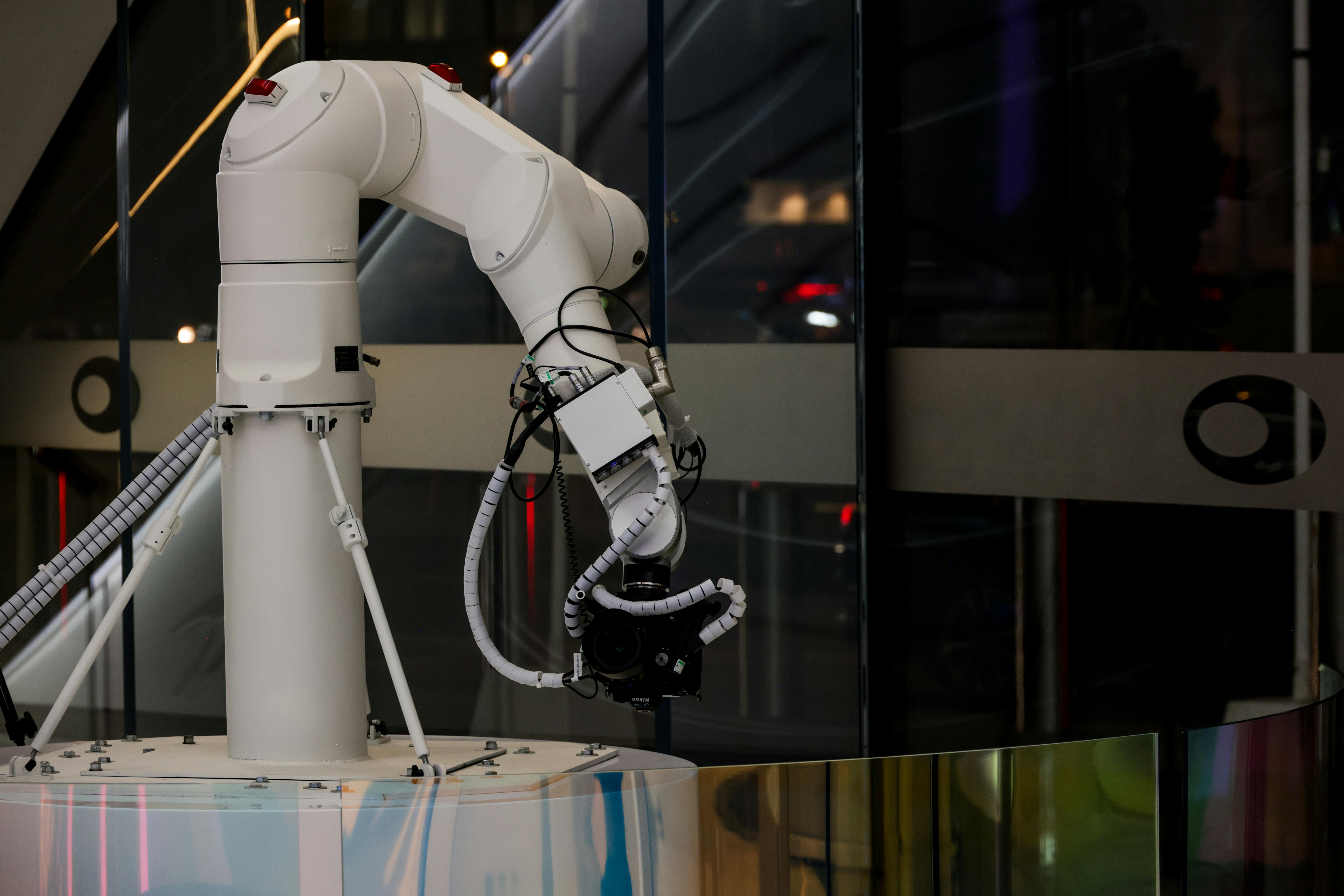 bras robotique blanc face à une baie vitrée.